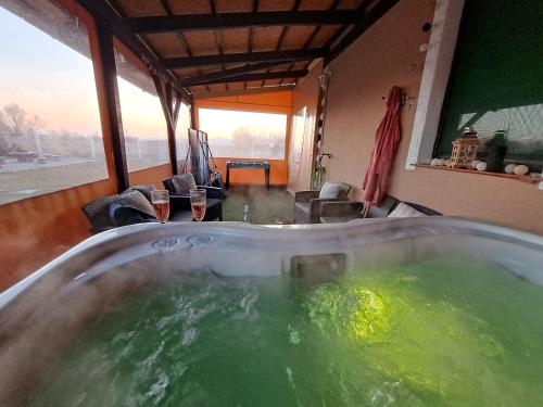 a bath tub filled with green water in a room at Berek Vendégház Fonyód in Fonyód