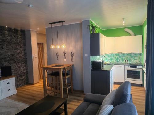 a living room and kitchen with a couch and a table at Green- Guest Apartment- Tapa in Tapa