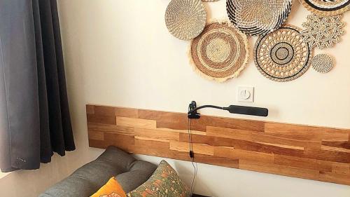 昂蒂布Ravissant studio au coeur du Vieil Antibes的客厅配有沙发,墙上挂着一些帽子