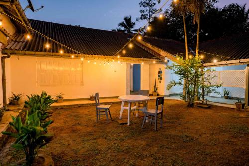 een tafel en stoelen voor een huis met verlichting bij Villa Eva in Matara