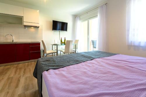 a bedroom with a bed and a kitchen and a table at Villa Veronika in Omiš