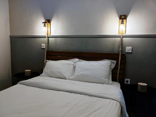 a bedroom with a bed with two lights on it at THE RUSTICK HOUSE - TRIKALA near the elf mill in Tríkala