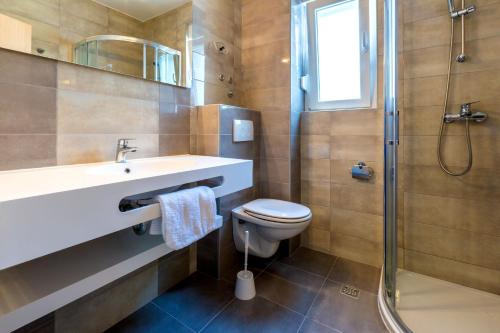 a bathroom with a sink and a toilet and a shower at Villa Veronika in Omiš