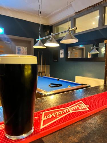 a glass of beer sitting on a counter with a pool table at The Gather Inn in Brighton & Hove