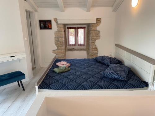 a bedroom with a bed with a blue comforter at Holiday Home Ava1 with pool & Holiday Home Ava2 with whirlpool in Baderna