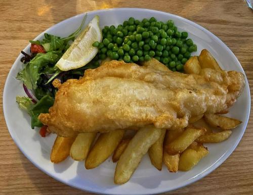 a plate of food with fish and fries and peas at The Gather Inn in Brighton & Hove