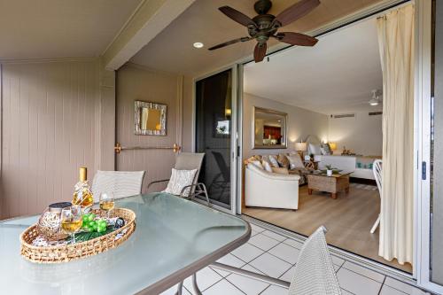 a dining room and living room with a ceiling fan at Maui Eldorado Condo G203 in Kaanapali