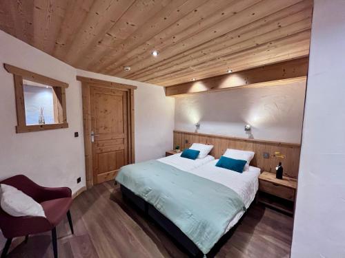 a bedroom with a bed and a wooden ceiling at Le Cosy - Appartement in Les Gets