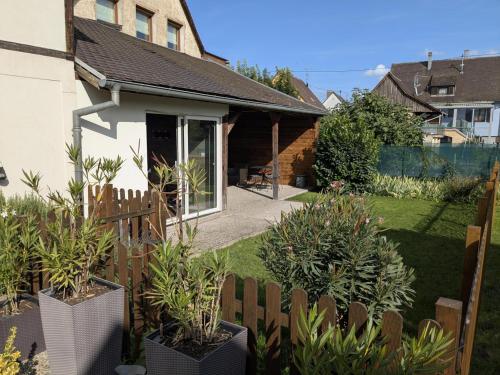 a house with a wooden fence and some plants at Au nid de cigo in Sigolsheim