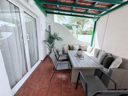 a patio with a couch and a table and chairs at HDFM Collection - Bungalow Playa del Inglés in Playa del Ingles