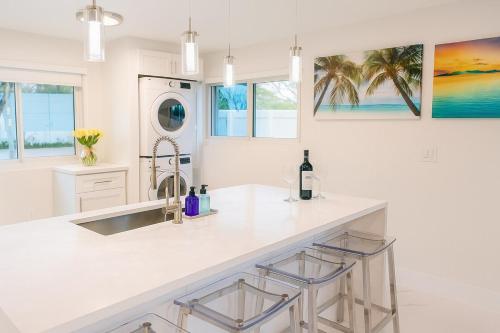 Una cocina blanca con fregadero y encimera. en Steps from Airport Hot Tub Bbq Boat Slip, en Dania Beach