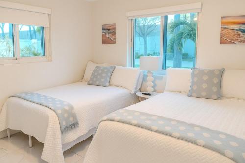 Dos camas en una habitación con dos ventanas. en Steps from Airport Hot Tub Bbq Boat Slip, en Dania Beach
