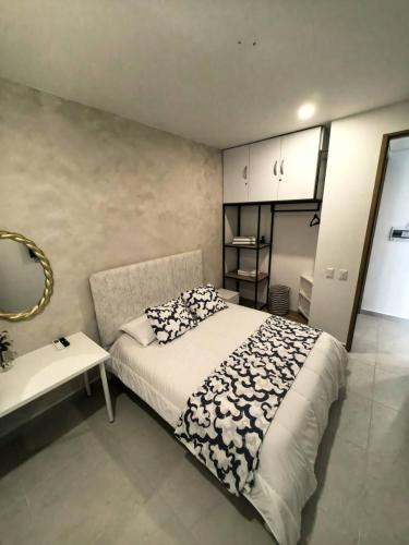 a bedroom with a bed and a table and a mirror at Palma-Suite-Santa-Marta in Estación El Salto