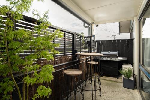 a balcony with two bar stools and plants at A Stone's Throw in Picton