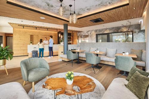 two people standing in a restaurant with a table and chairs at Hotel Amberger Hof in Bad Koetzting