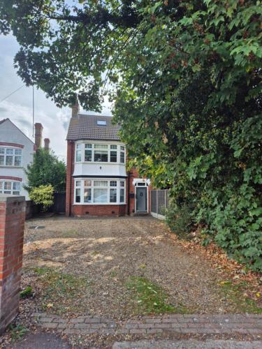 a large house with a driveway in front of it at Luxury room's with ensuite and kitchen, parking in Slough Centre in Slough