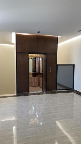 an empty room with a large wooden wall and a screen at شقة غرفة وصالة اطلالة على البرج in Al Kharj