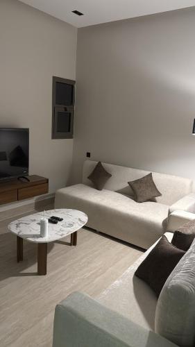 a living room with a couch and a coffee table at شقة غرفة وصالة اطلالة على البرج in Al Kharj
