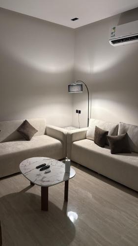 a living room with a couch and a table at شقة غرفة وصالة اطلالة على البرج in Al Kharj