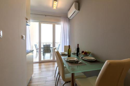 a dining room with a green table and chairs at Villa Veronika in Omiš