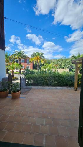 a patio with palm trees and a blue sky at Casa Candeleda Alojamiento Boutique in Candeleda
