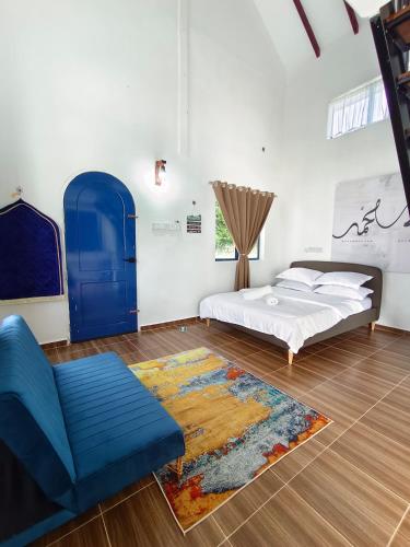 a bedroom with a bed and a blue chair and a rug at De'5 Tiny House , Besut in Kampong Kubang Bemban