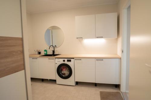 een keuken met een wasmachine en een wastafel bij Villa Valaja in Rovaniemi
