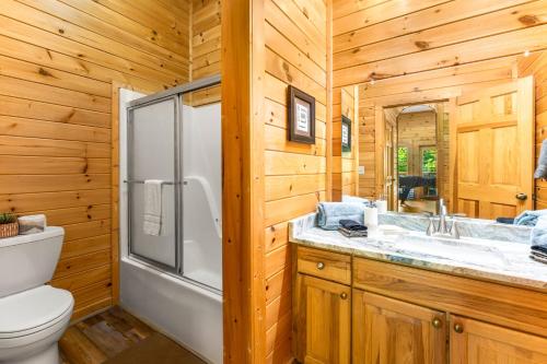 un bagno con doccia, WC e lavandino di Briar Brook - Private Smoky Mountain Luxury Log Home with 2 Fireplaces, Hot Tub & Community Pool a Sevierville