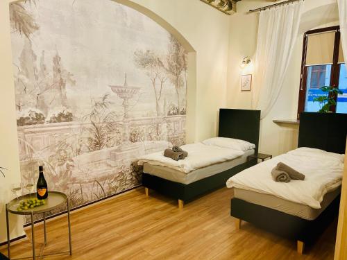 two beds in a room with a mural on the wall at Katedralna Apartamenty in Legnica