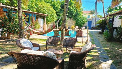 a group of chairs and hammocks in a yard at Casarão da Brisa in Ilha do Tatu