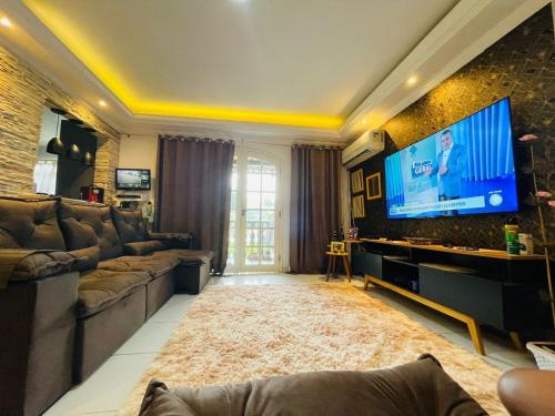a living room with a large flat screen tv at Casarão da Brisa in Ilha do Tatu