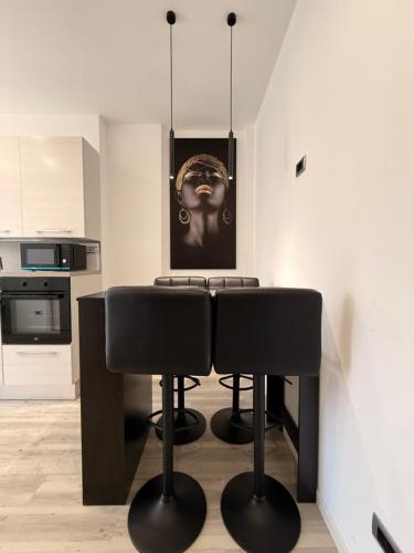 ファルコナーラ・マリッティマにあるAppartamento Moderno, Comfort, Mare e Posizione Topのキッチン(黒い椅子とテーブル付)