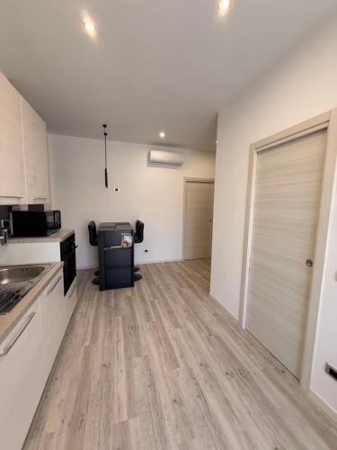 ファルコナーラ・マリッティマにあるAppartamento Moderno, Comfort, Mare e Posizione Topの白い壁とウッドフロアの広いキッチン