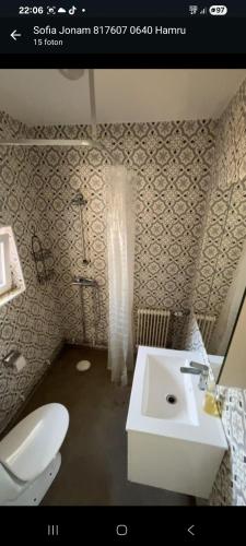 a bathroom with a white sink and a toilet at Östa 264 in Märsta