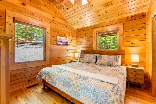 una camera da letto con un letto in una cabina di legno di Briar Brook - Private Smoky Mountain Luxury Log Home with 2 Fireplaces, Hot Tub & Community Pool a Sevierville