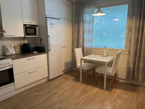 a kitchen with a table and chairs and a window at Apartment in Seinäjoki city in Seinäjoki