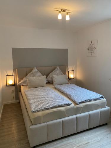 a large bed in a room with two lights at Ferienwohnung Ambiente in Klotten