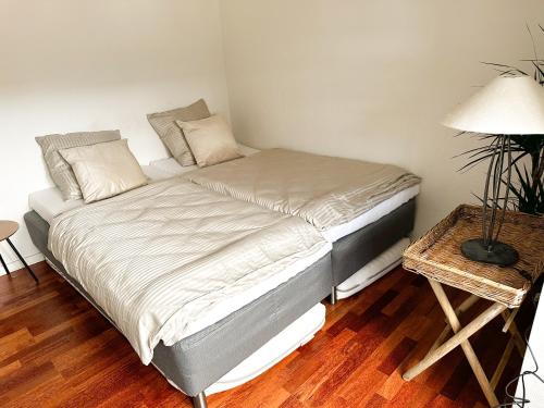 a bed in a room with a lamp and a table at Deluxe Apartment on the Main Street with Free Parking & Late Checkout in Herning