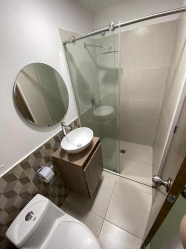 a bathroom with a shower and a sink and a mirror at Hotel pasarela real cali in Cali