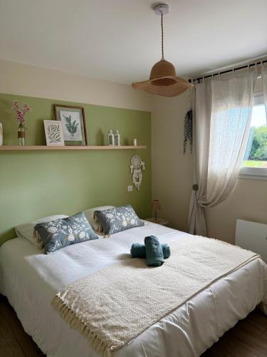 a bedroom with a large white bed with two pillows at Le Clos Es Rio in Plourhan