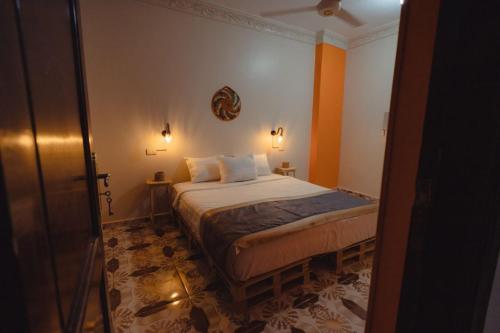 アスワンにあるPajama Hostelのオレンジ色の壁のベッドルーム1室(ベッド1台付)