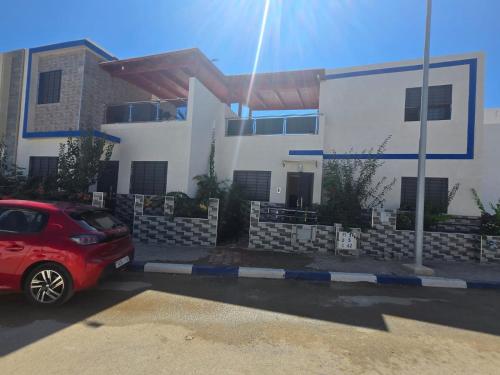 a red car parked in front of a house at Mini villa 1 Al hoceima in Al Hoceïma