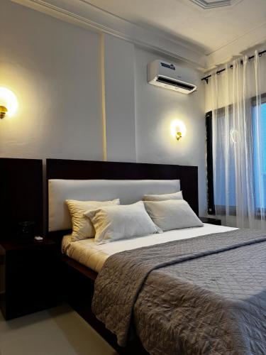 a bedroom with a large bed and a window at Sublime appartement à Bonamoussadi in Douala