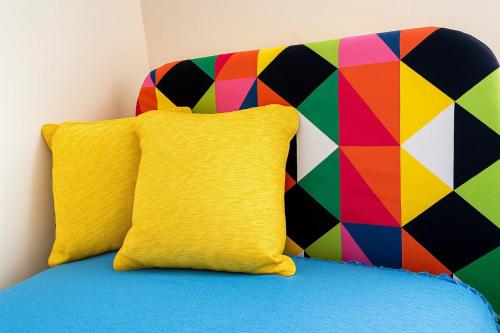 a bed with a colorful pillow and a colorful wall at Slavia in Castleknock