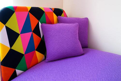 a bed with a purple pillow and a colorful blanket at Slavia in Castleknock