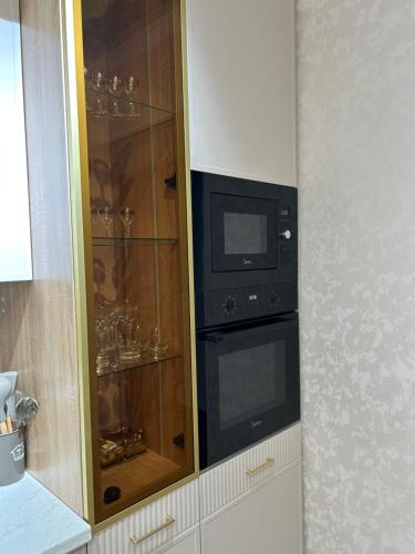 Un armario con un microondas y un televisor dentro. en 3 комнатный апартамент на Батыс 2, en Aktobe