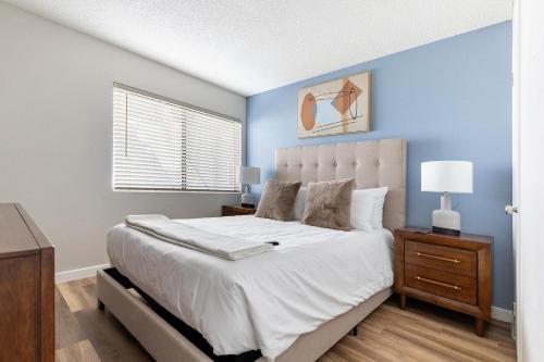 ein Schlafzimmer mit einem großen Bett mit einer blauen Wand in der Unterkunft Landing Apartments Phoenix - Maryvale Village in Phoenix