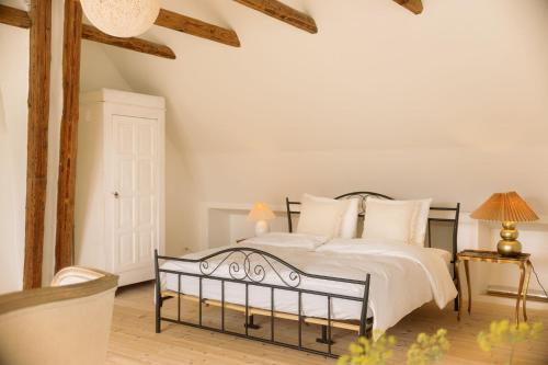 a bedroom with a bed with white sheets and pillows at Romantic farmhouse with wonderful garden in Ærøskøbing