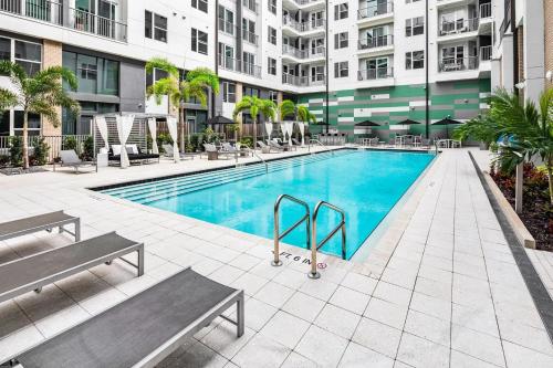 a swimming pool in a building with two benches at Landing Modern 1BD Rooftop Lounge Gym in Orlando