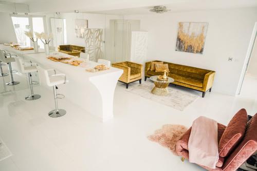 een witte woonkamer met een lange tafel en stoelen bij JazzFarm GuestHouse in Bîrnova